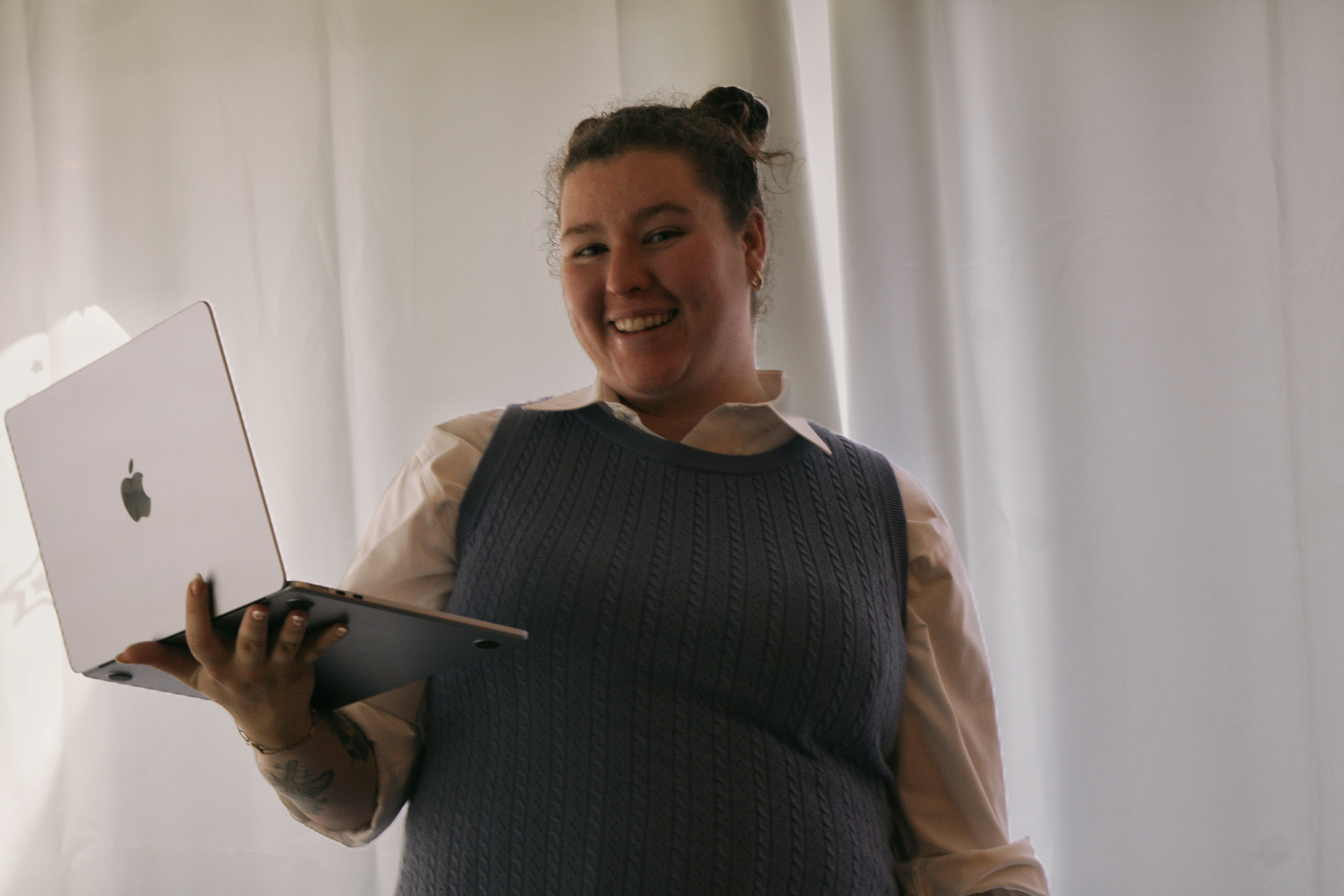 Victoria DeVita smiling and holding a laptop